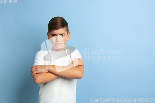Image of Caucasian teen\'s portrait isolated on blue studio background