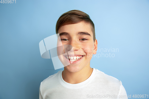 Image of Caucasian teen\'s portrait isolated on blue studio background