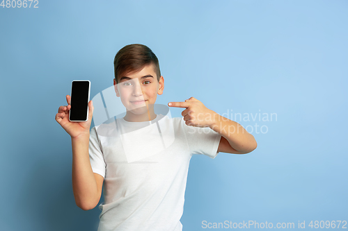 Image of Caucasian teen\'s portrait isolated on blue studio background