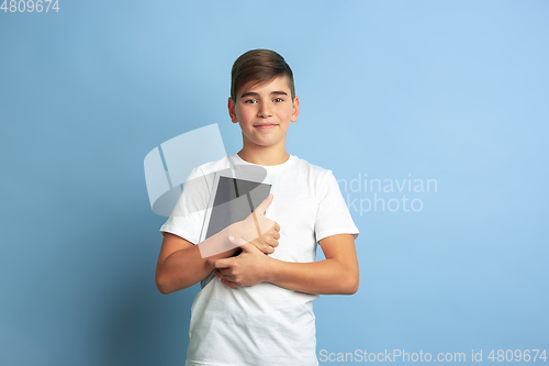 Image of Caucasian teen\'s portrait isolated on blue studio background