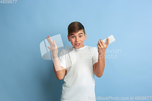 Image of Caucasian teen\'s portrait isolated on blue studio background