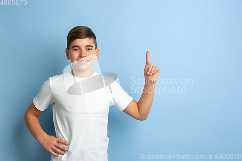 Image of Caucasian teen\'s portrait isolated on blue studio background