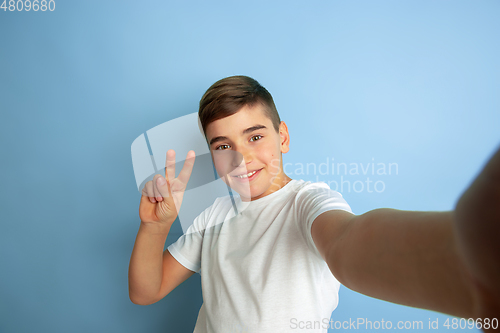 Image of Caucasian teen\'s portrait isolated on blue studio background