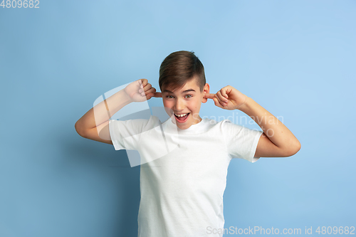 Image of Caucasian teen\'s portrait isolated on blue studio background