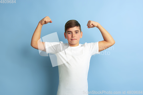 Image of Caucasian teen\'s portrait isolated on blue studio background