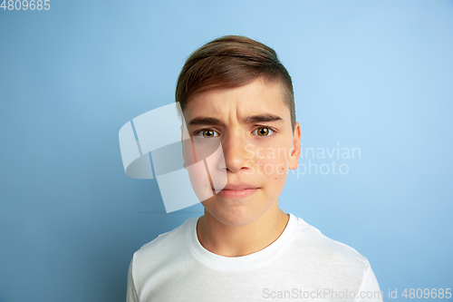 Image of Caucasian teen\'s portrait isolated on blue studio background