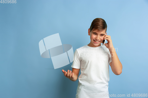 Image of Caucasian teen\'s portrait isolated on blue studio background