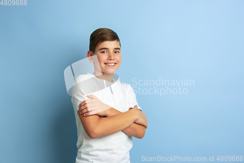 Image of Caucasian teen\'s portrait isolated on blue studio background
