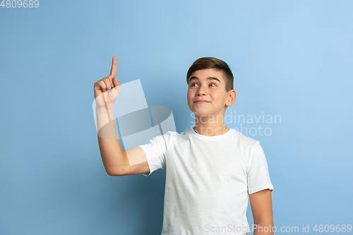 Image of Caucasian teen\'s portrait isolated on blue studio background