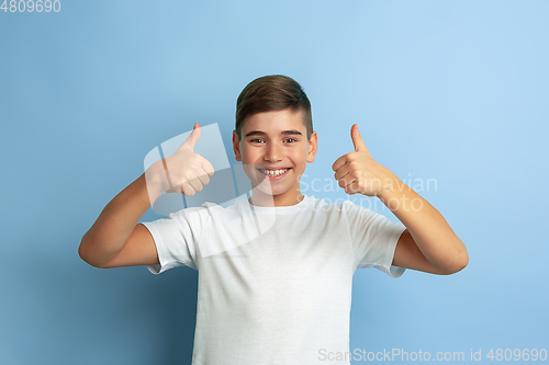 Image of Caucasian teen\'s portrait isolated on blue studio background