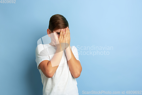 Image of Caucasian teen\'s portrait isolated on blue studio background