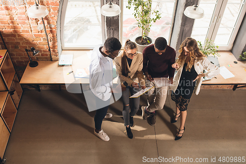 Image of Colleagues working together in modern office using devices and gadgets during negotiations. Top view.