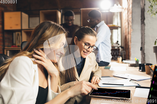 Image of Colleagues working together in modern office using devices and gadgets during negotiations