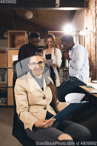 Image of Colleagues working together in modern office using devices and gadgets during negotiations