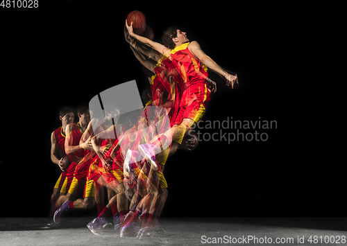 Image of Young caucasian basketball player in motion and action in mixed light on dark background. Concept of healthy lifestyle, professional sport, hobby.