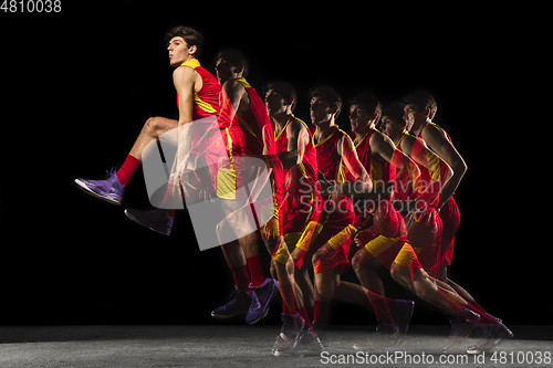 Image of Young caucasian basketball player in motion and action in mixed light on dark background. Concept of healthy lifestyle, professional sport, hobby.