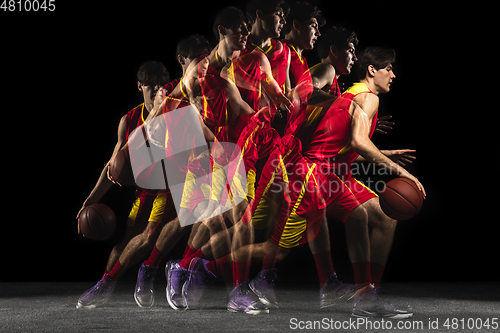 Image of Young caucasian basketball player in motion and action in mixed light on dark background. Concept of healthy lifestyle, professional sport, hobby.