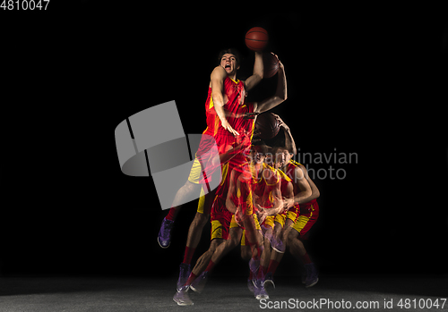 Image of Young caucasian basketball player in motion and action in mixed light on dark background. Concept of healthy lifestyle, professional sport, hobby.