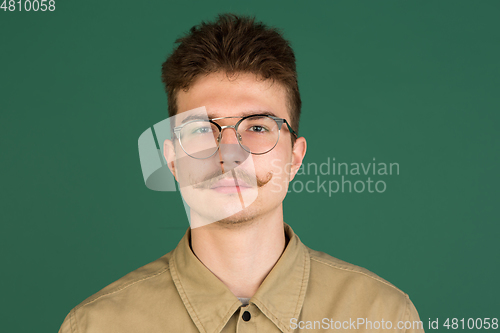 Image of Caucasian man\'s portrait isolated over green studio background with copyspace