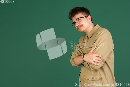 Image of Caucasian man\'s portrait isolated over green studio background with copyspace
