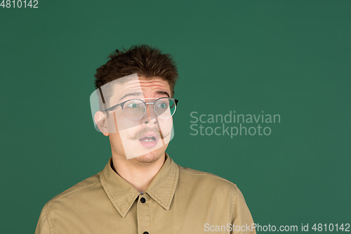 Image of Caucasian man\'s portrait isolated over green studio background with copyspace