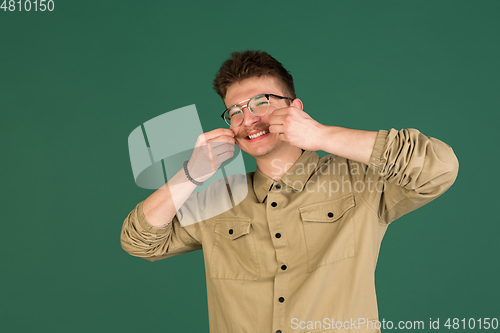 Image of Caucasian man\'s portrait isolated over green studio background with copyspace