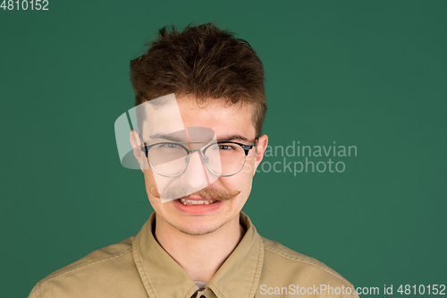 Image of Caucasian man\'s portrait isolated over green studio background with copyspace