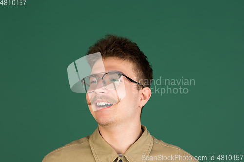 Image of Caucasian man\'s portrait isolated over green studio background with copyspace