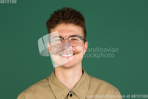 Image of Caucasian man\'s portrait isolated over green studio background with copyspace