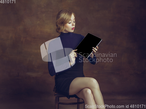 Image of Young woman in art action isolated on brown background. Retro style, comparison of eras concept.