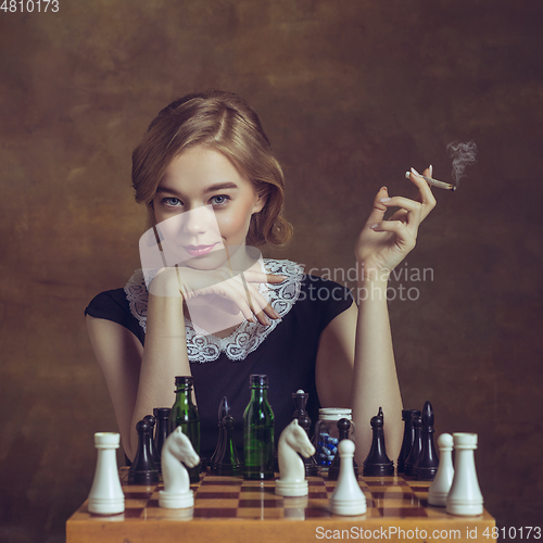 Image of Young woman in art action isolated on brown background. Retro style, comparison of eras concept.