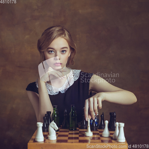 Image of Young woman in art action isolated on brown background. Retro style, comparison of eras concept.