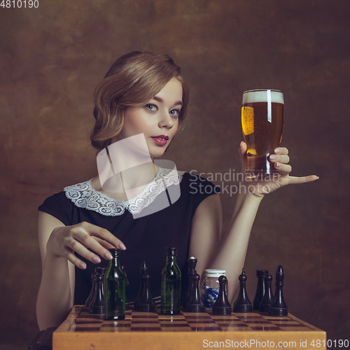 Image of Young woman in art action isolated on brown background. Retro style, comparison of eras concept.