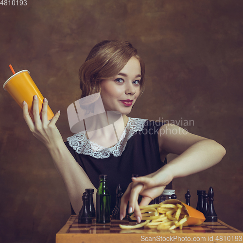 Image of Young woman in art action isolated on brown background. Retro style, comparison of eras concept.