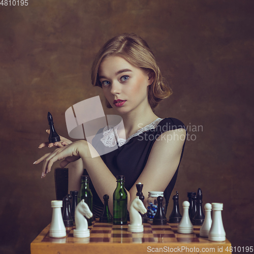 Image of Young woman in art action isolated on brown background. Retro style, comparison of eras concept.