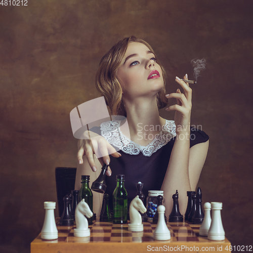 Image of Young woman in art action isolated on brown background. Retro style, comparison of eras concept.