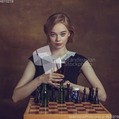 Image of Young woman in art action isolated on brown background. Retro style, comparison of eras concept.