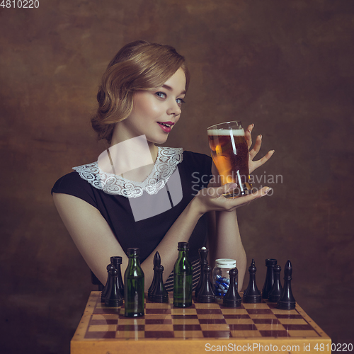 Image of Young woman in art action isolated on brown background. Retro style, comparison of eras concept.