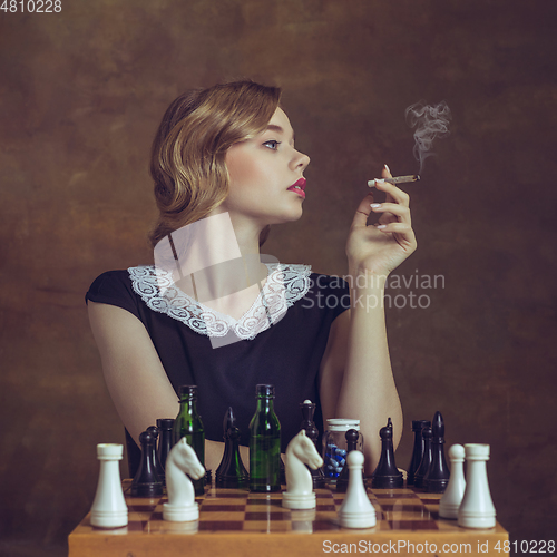 Image of Young woman in art action isolated on brown background. Retro style, comparison of eras concept.