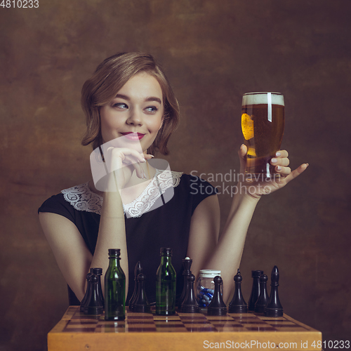 Image of Young woman in art action isolated on brown background. Retro style, comparison of eras concept.