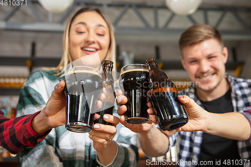 Image of Group of friends watching sport match together. Emotional fans cheering for favourite team, watching on exciting game. Concept of friendship, leisure activity, emotions