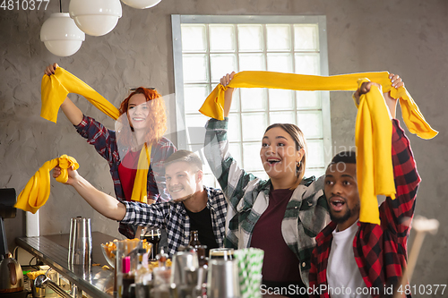 Image of Group of friends watching sport match together. Emotional fans cheering for favourite team, watching on exciting game. Concept of friendship, leisure activity, emotions