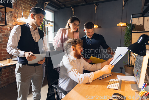 Image of Colleagues working together in modern office using devices and gadgets during creative meeting