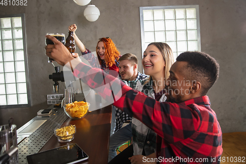 Image of Group of friends watching sport match together. Emotional fans cheering for favourite team, watching on exciting game. Concept of friendship, leisure activity, emotions