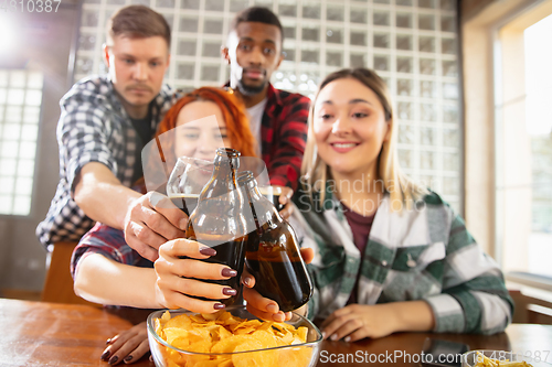 Image of Group of friends watching sport match together. Emotional fans cheering for favourite team, watching on exciting game. Concept of friendship, leisure activity, emotions