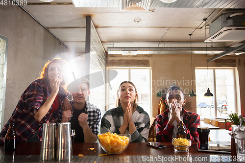 Image of Group of friends watching sport match together. Emotional fans cheering for favourite team, watching on exciting game. Concept of friendship, leisure activity, emotions