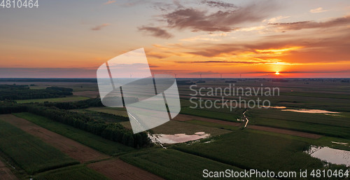 Image of Colorful sunset over forest and fields aerial