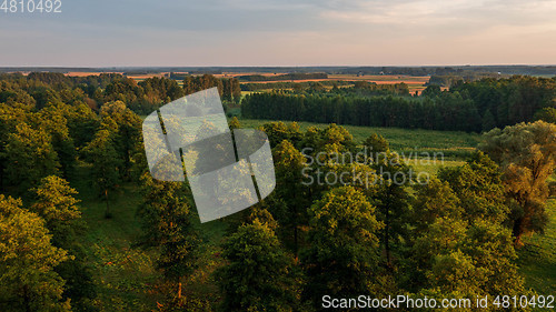 Image of Colorful sunset over forest and fields aerial