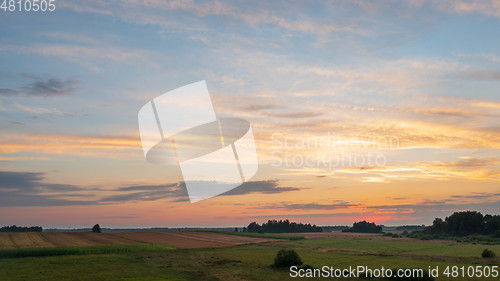 Image of Colorful sunset over forest and fields aerial