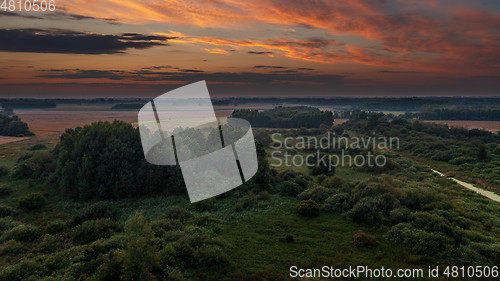 Image of Colorful sunset over forest and fields aerial